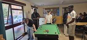 Young people socialising and playing pool during a UAA Youth Club session.