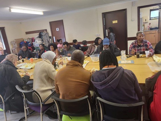 Community members seated around tables sharing a UAA community lunch.