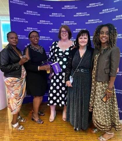 Members of the UAA community at the BBC Radio Northampton Make a Difference Awards in front of a BBC Radio Northampton backdrop